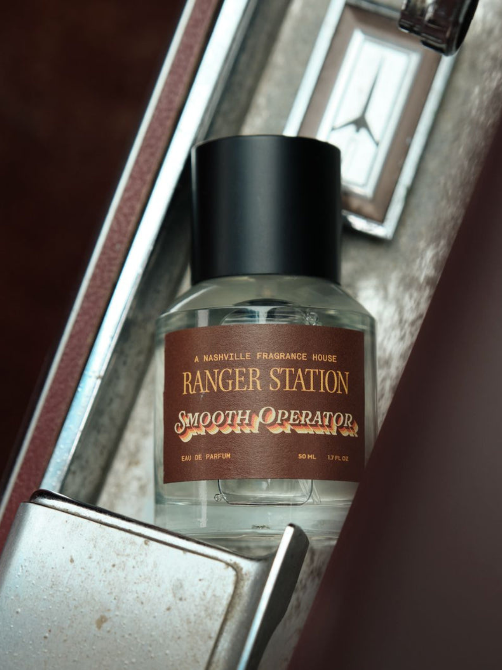 Ranger Station Eau de Parfum in Smooth Operator Scent 50mL bottle in a car